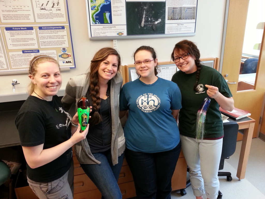 four lab members one holding tag one holding sculpture