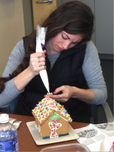 student frosting gingerbread house