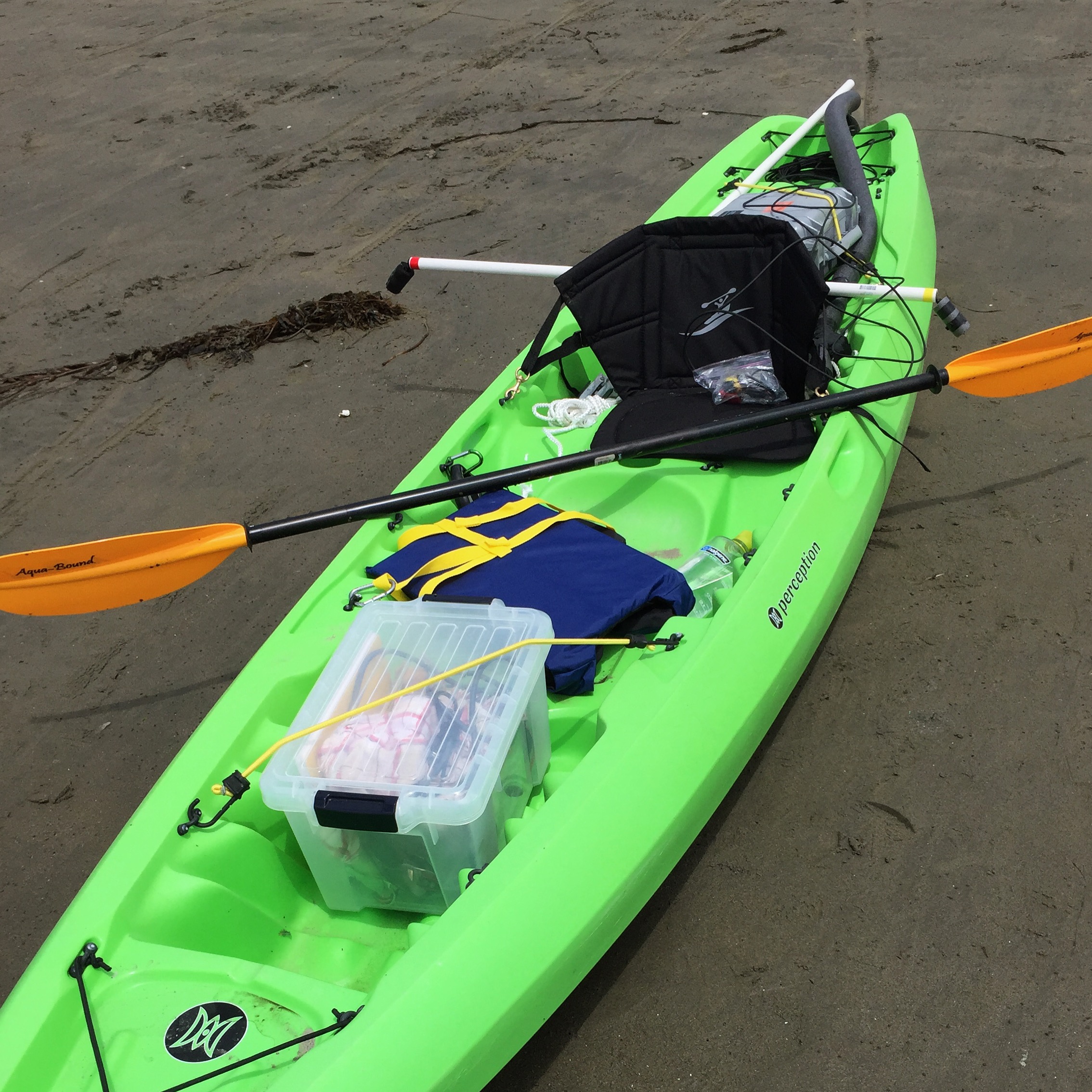 bright green kayak on beach loaded with equipment