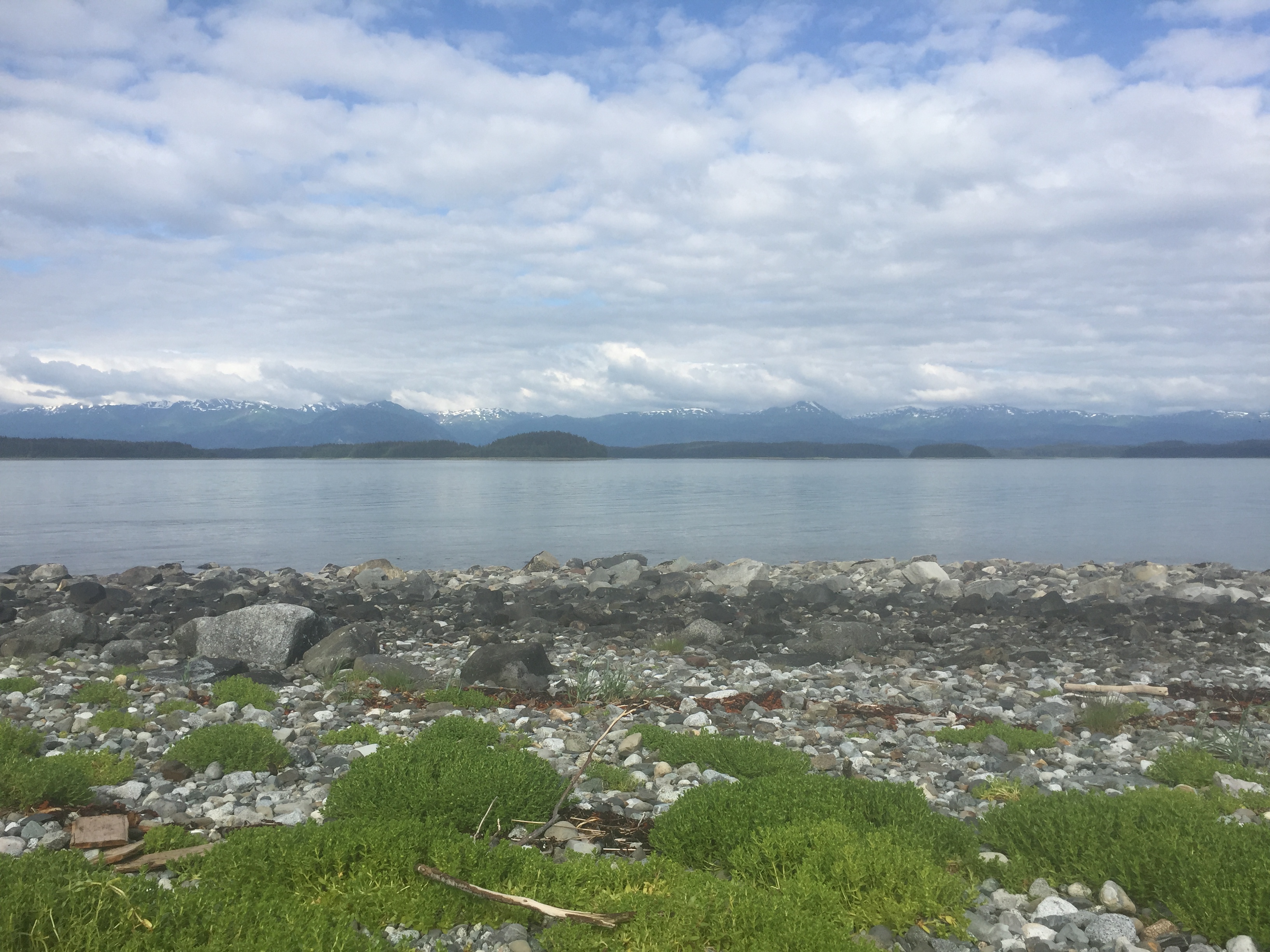 water shoreline with mountains in background